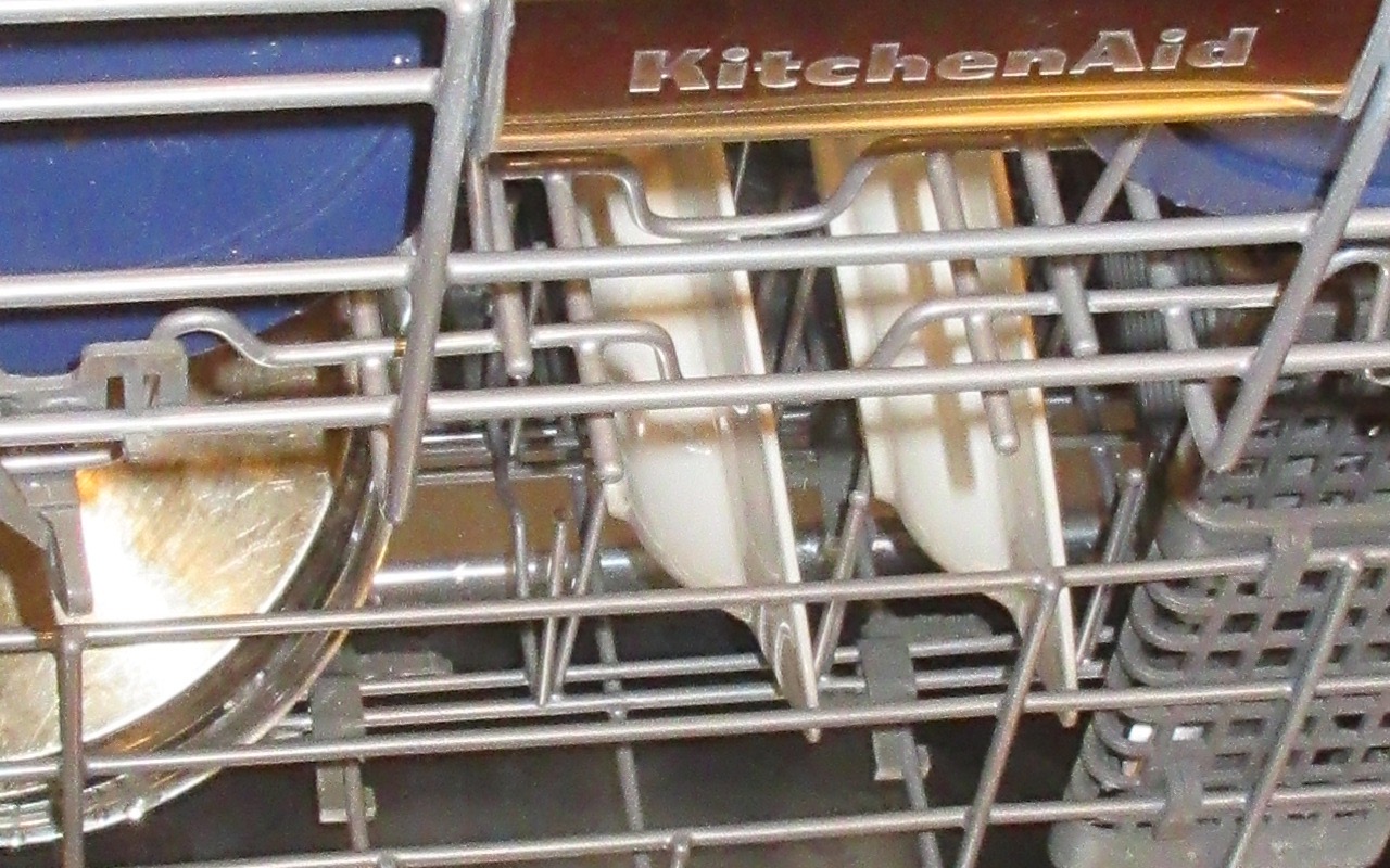 An open dishwasher loaded with dishes in a home kitchen